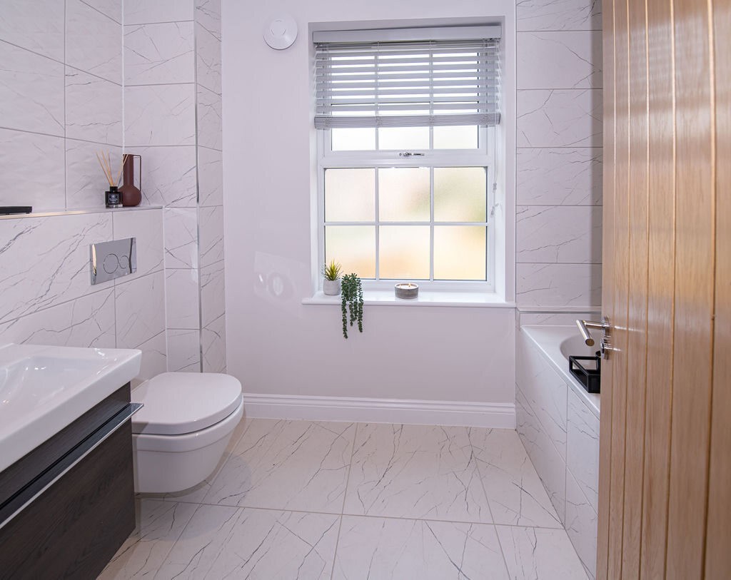 white tiled bathroom with bath toilet and sink