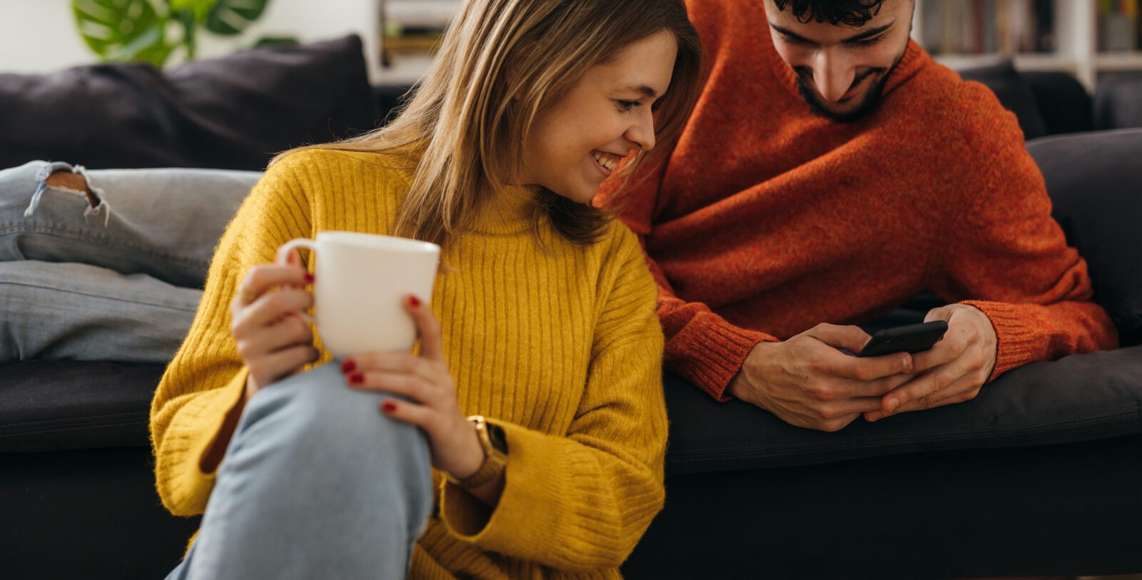 two people looking at a mobile phone in a living room