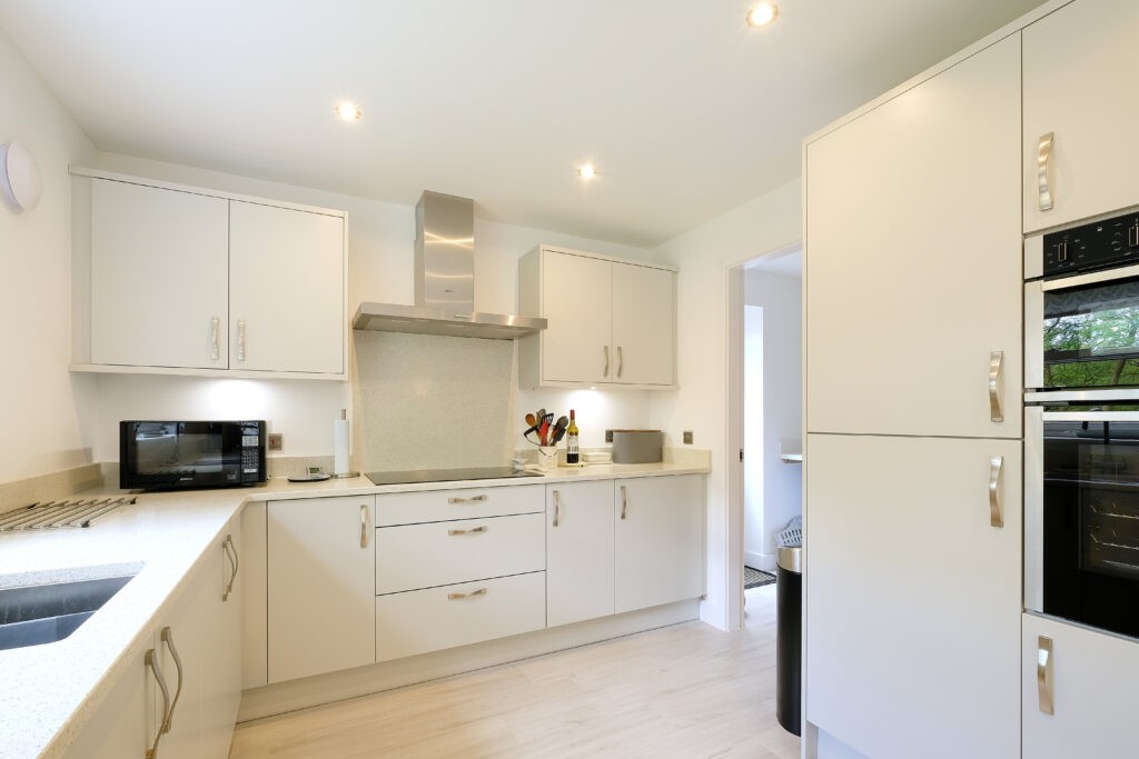 kitchen inside new build with white cabinets and integrated oven