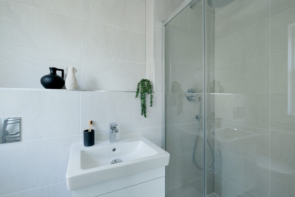 bathroom with walk in shower and sink next to it